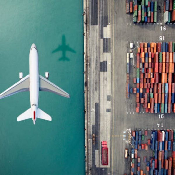 Airplane flying over container port